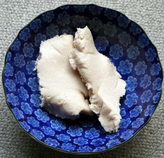 Beauty Secrets of Japan sake bath salts in a decorative blue floral ceramic bowl for a relaxing self-care ritual.