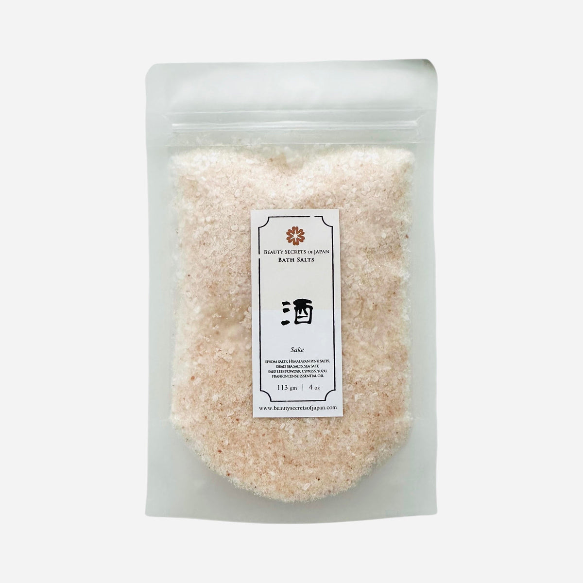 Beauty Secrets of Japan Sake Bath Salts in a clear pouch with pink Himalayan and sea salt blend for a relaxing soak.